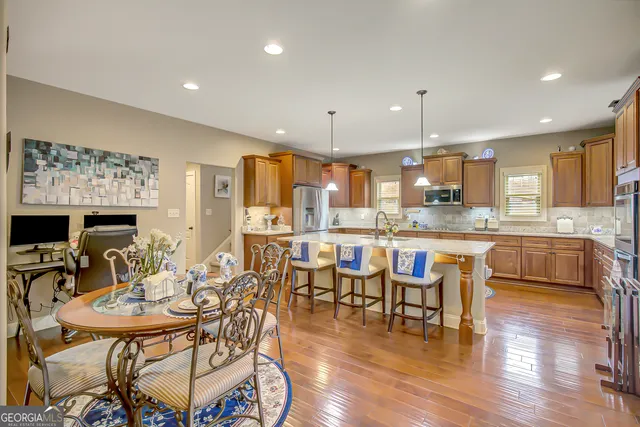 a kitchen with stainless steel appliances granite countertop a sink a stove and a wooden floors