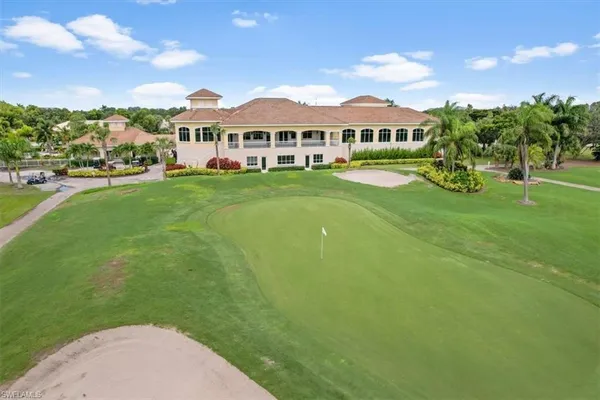 a view of a white house with a big yard and potted plants