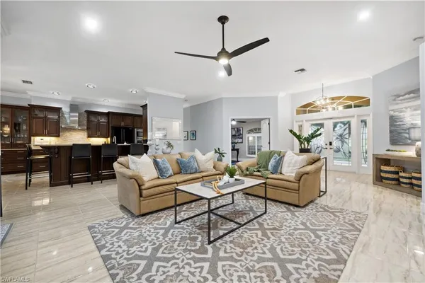 a living room with furniture kitchen view and a chandelier