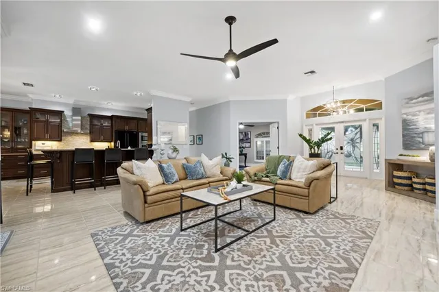 a living room with furniture kitchen view and a chandelier