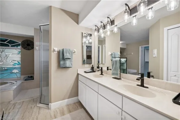 a spacious bathroom with a double vanity sink a mirror and shower