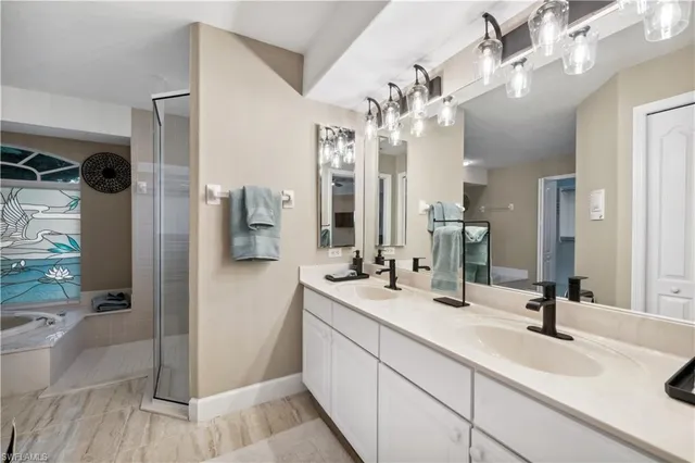 a spacious bathroom with a double vanity sink a mirror and shower