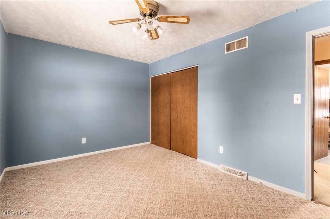 4875 New Road Youngstown, OH 44515 - Photo 15 of 25 bedroom with ceiling fan, a closet, and carpet flooring