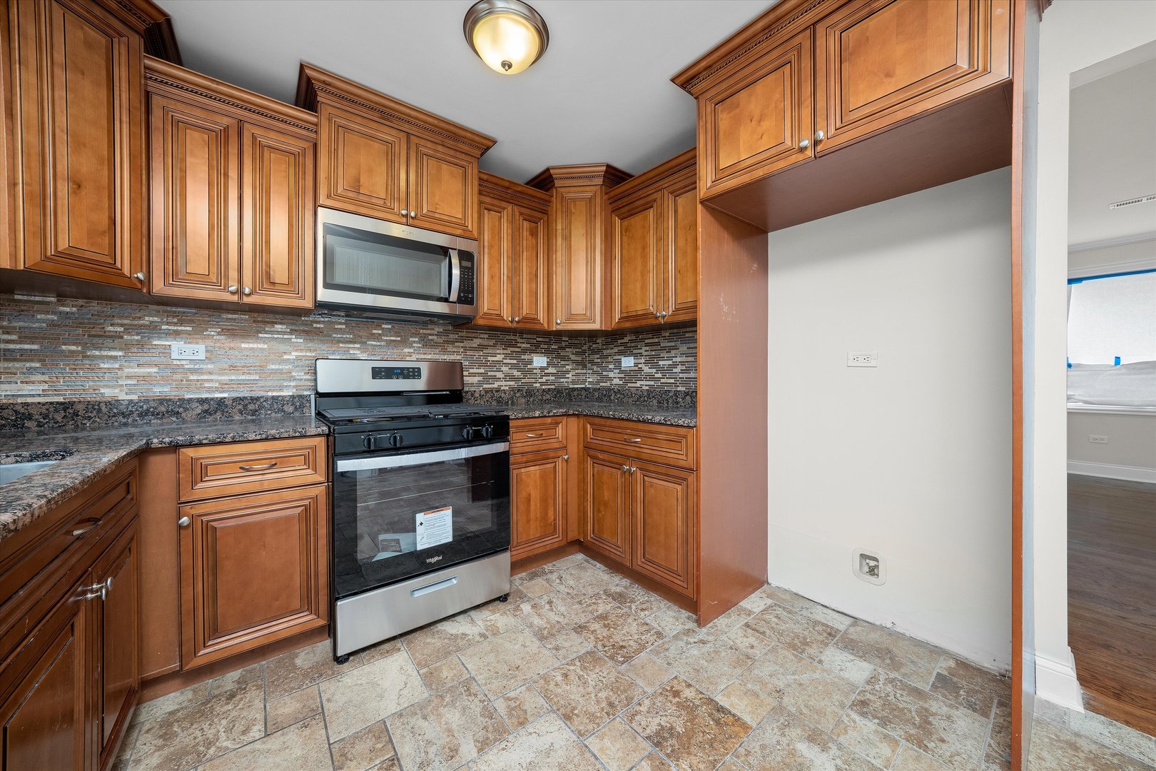 7918 74th Street Bridgeview, IL 60455 - Photo 12 of 26 a kitchen with stainless steel appliances granite countertop a stove a sink and a microwave