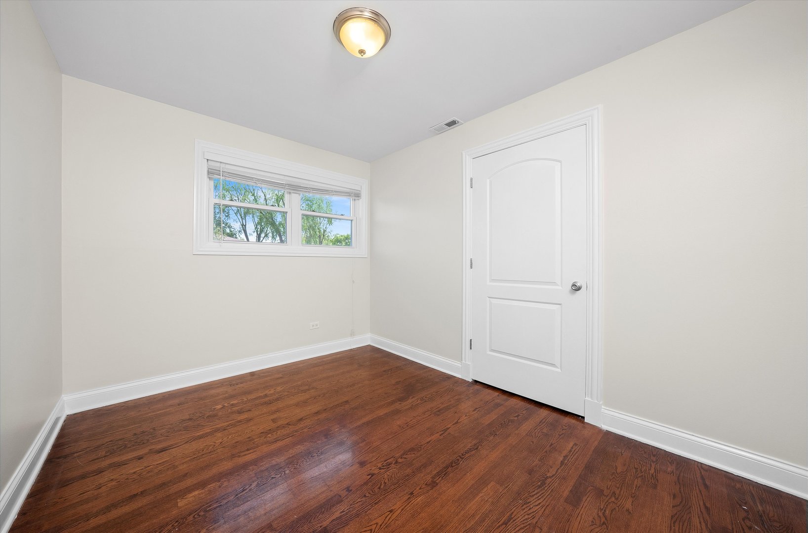 7918 74th Street Bridgeview, IL 60455 - Photo 17 of 26 an empty room with wooden floor and window