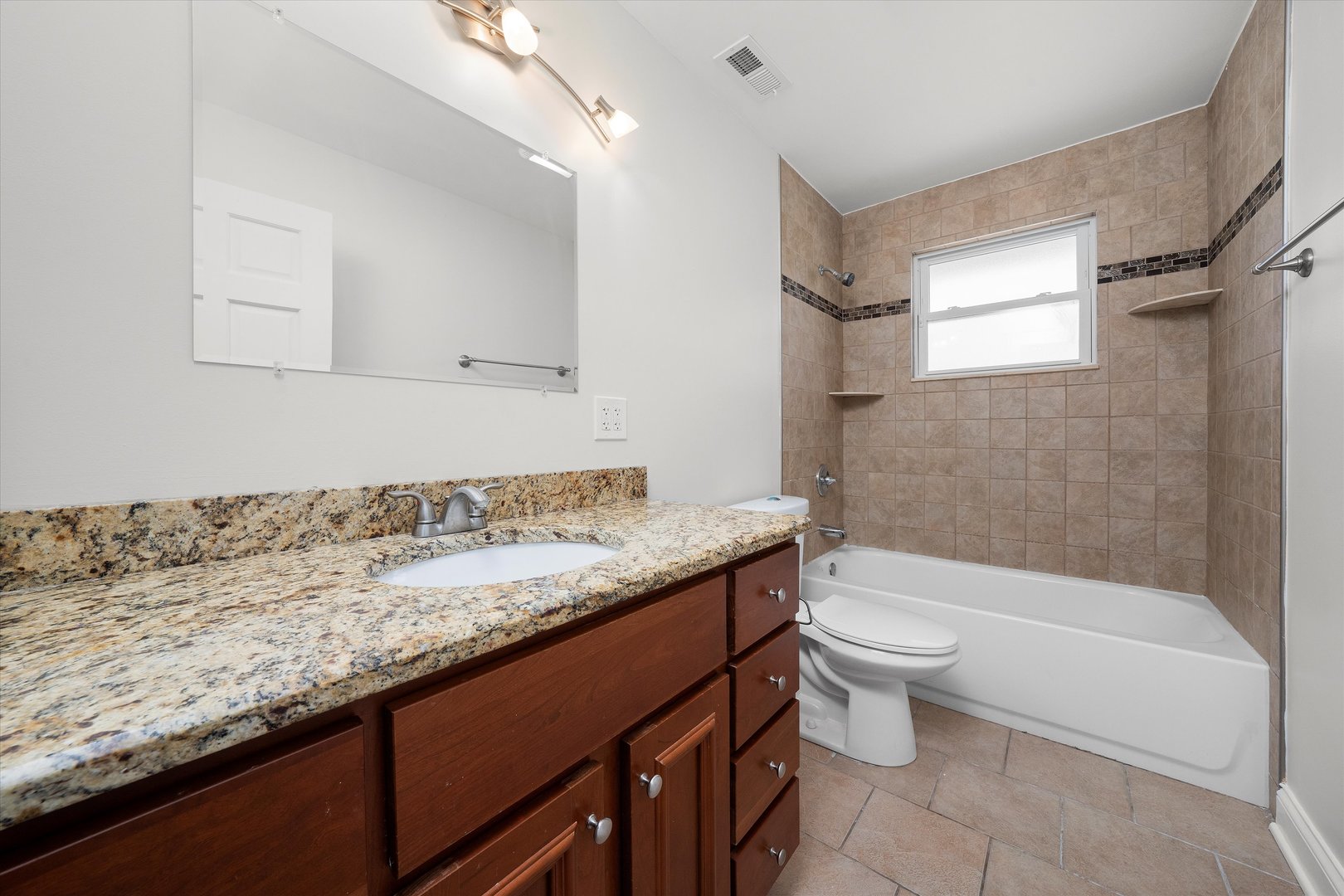 7918 74th Street Bridgeview, IL 60455 - Photo 23 of 26 a bathroom with a granite countertop sink a toilet and bathtub