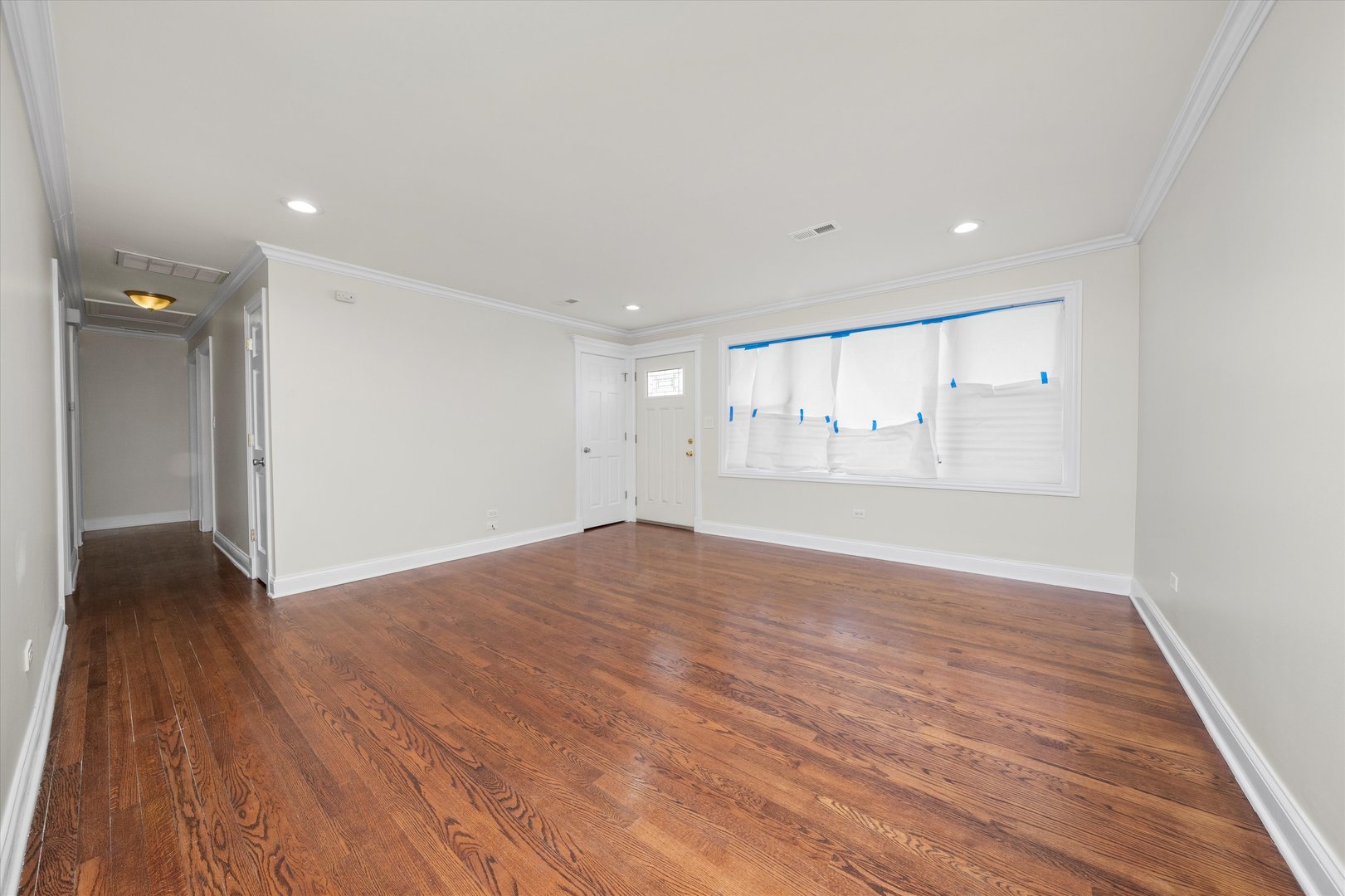 7918 74th Street Bridgeview, IL 60455 - Photo 7 of 26 a view of an empty room with wooden floor and a window