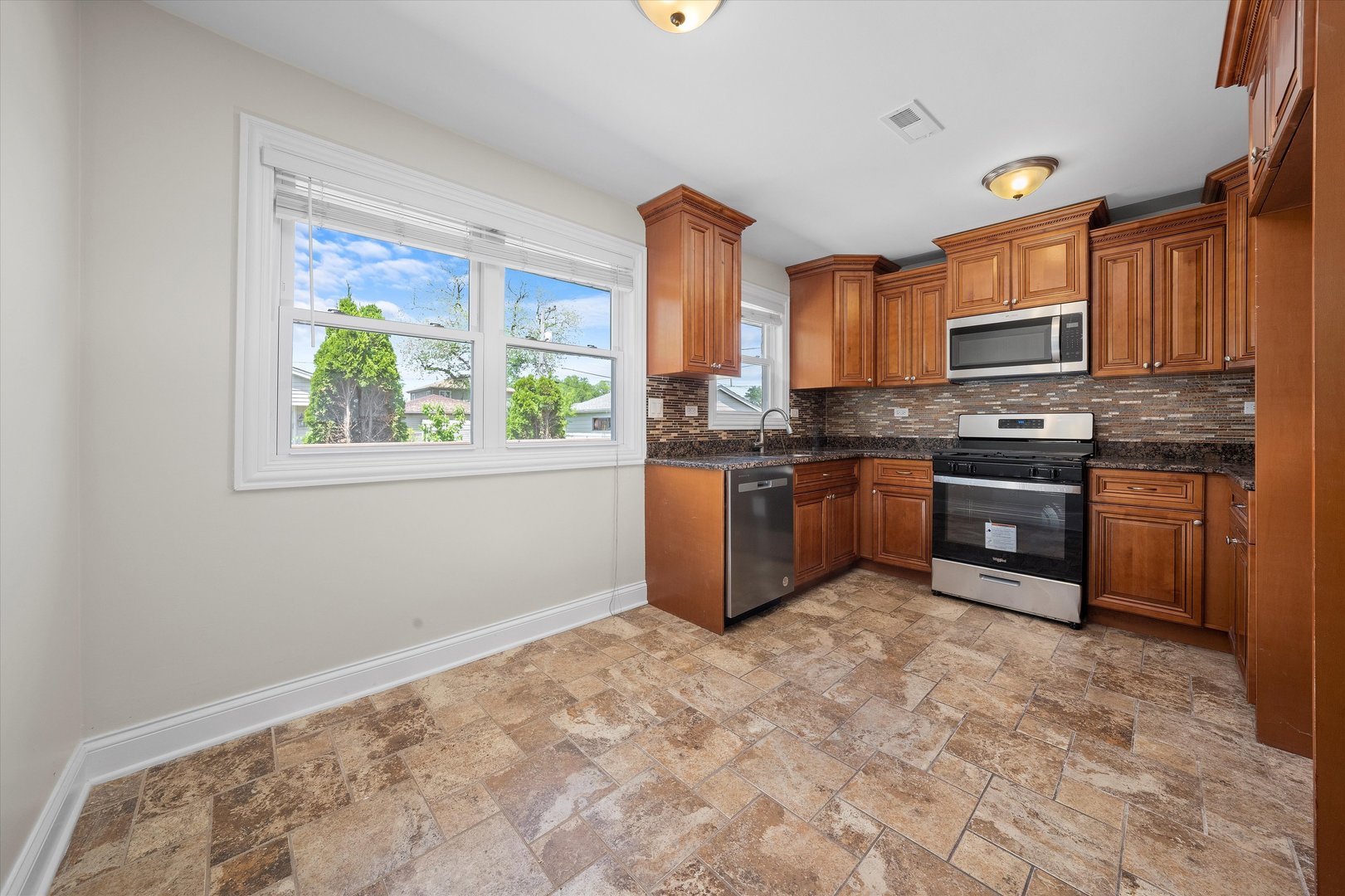 7918 74th Street Bridgeview, IL 60455 - Photo 9 of 26 a kitchen with stainless steel appliances granite countertop a stove sink and cabinets