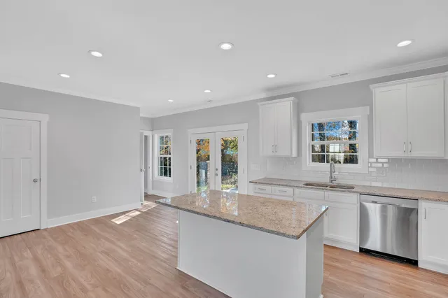 an empty room with windows and ceiling fan