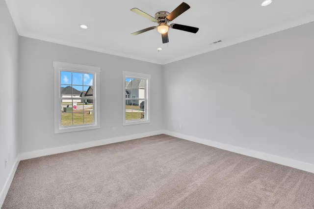 an empty room with a window and a fan