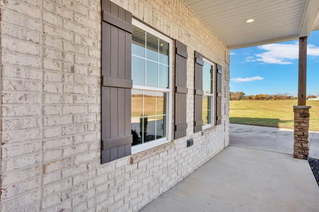 a view of empty room with wooden floor and window