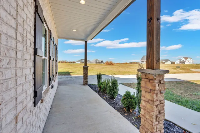 a kitchen with stainless steel appliances granite countertop a sink dishwasher a refrigerator and white cabinets with wooden floor