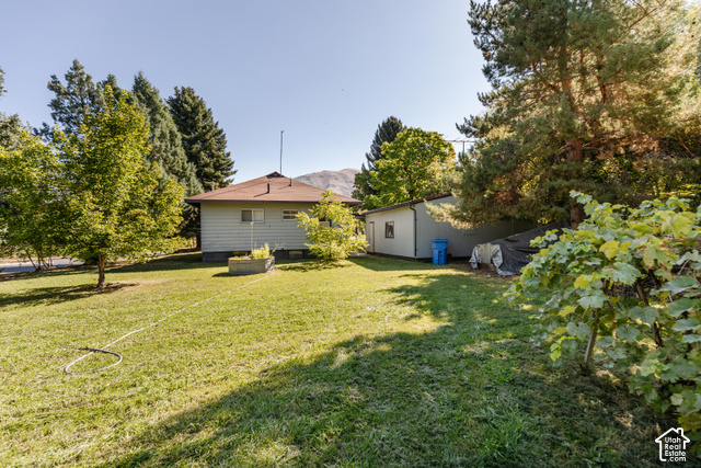 3959 Main Street Logan, UT 84321 - Photo 28 of 35 Expansive lawn surrounding the property, mature trees providing shade, and a separate outbuilding