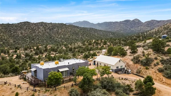 an aerial view of a house with a mountain