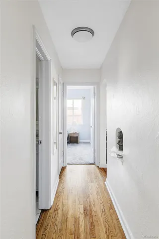 a view of a hallway with wooden floor and closet