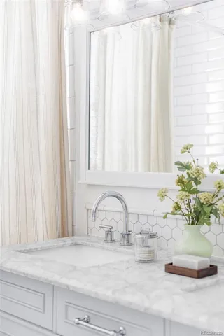 a close view of a sink a mirror and a potted plant