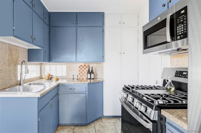 a kitchen with stainless steel appliances granite countertop a sink stove and microwave