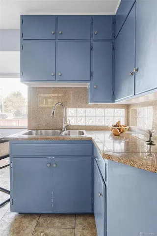 a kitchen with granite countertop a sink a stove and cabinets