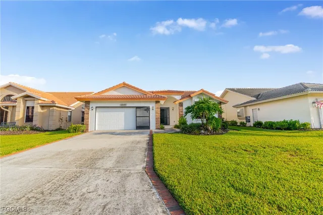 a view of a big house with a big yard and palm trees