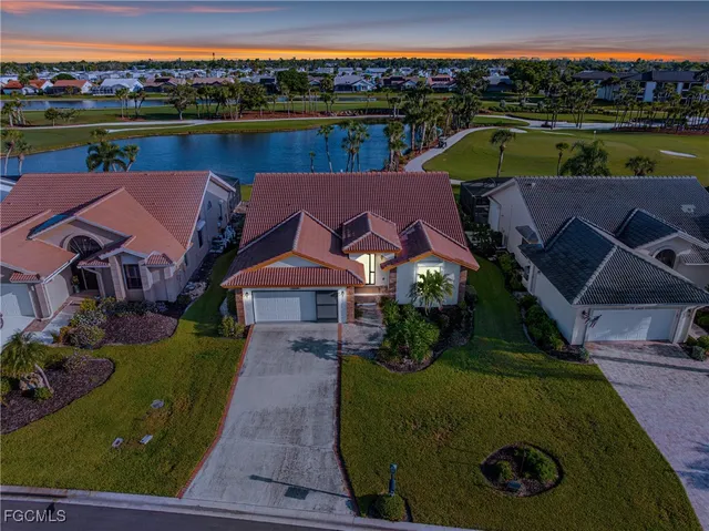 an aerial view of a house with a garden and lake view