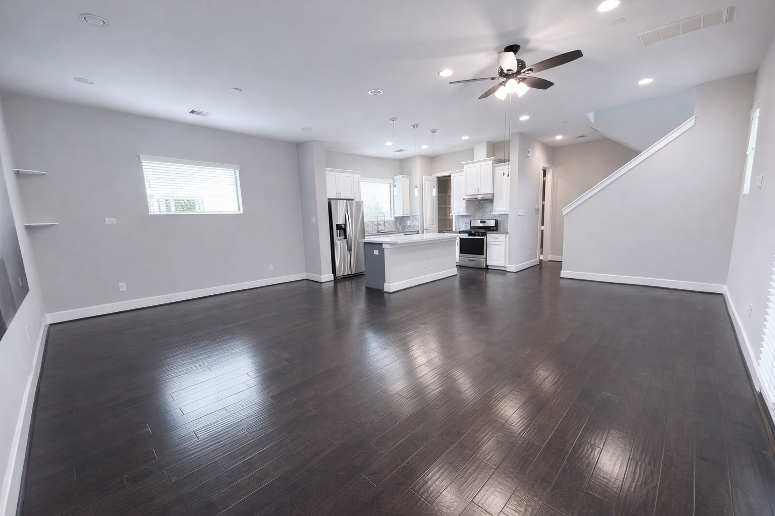 10806 Warwana Road, Unit C Houston, TX 77043 - Photo 4 of 35 a view of an empty room with wooden floor and a kitchen