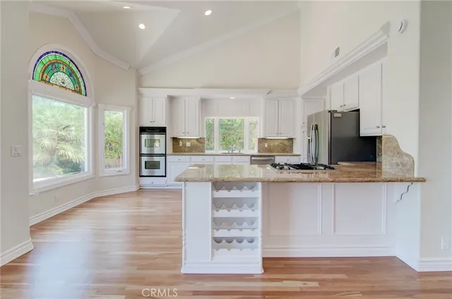 a kitchen with stainless steel appliances granite countertop a stove top oven a sink a counter space and cabinets