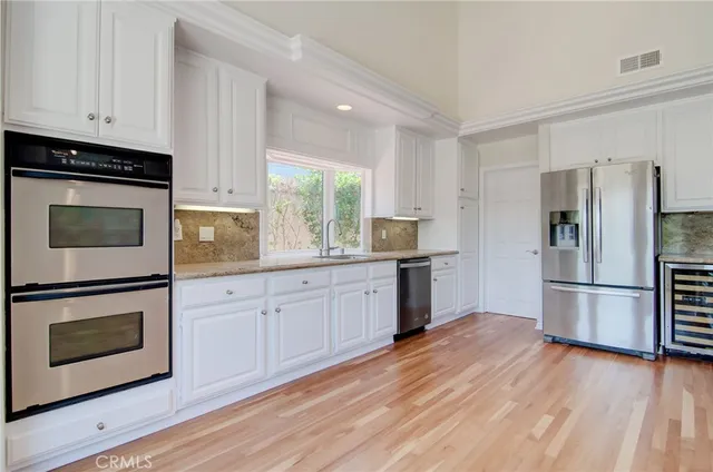 a kitchen with granite countertop a refrigerator stove and microwave