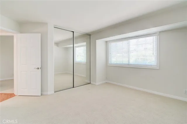 an empty room with windows and closet