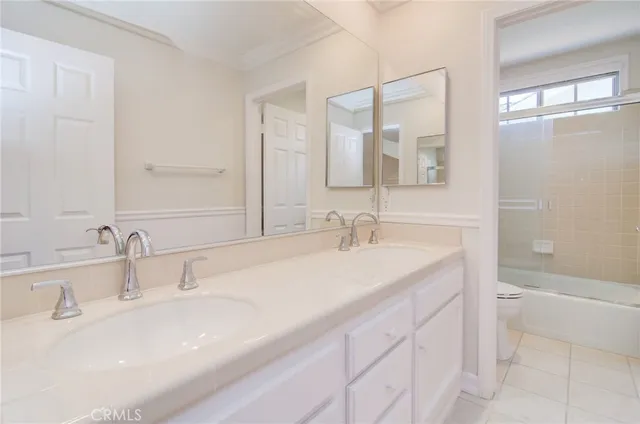 a bathroom with double sink and a mirror