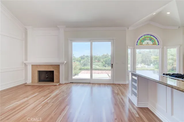 a view of empty room with wooden floor and a fireplace