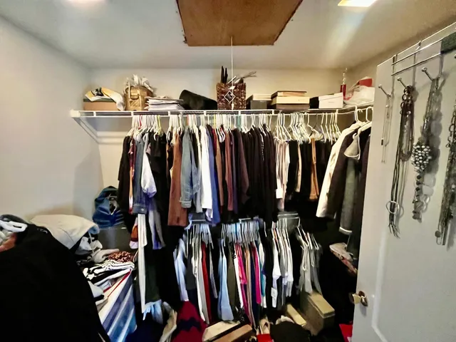 a view of walk in closet with clothes and shoes