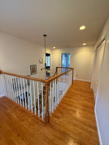 a view of a hallway with wooden floor and stairs