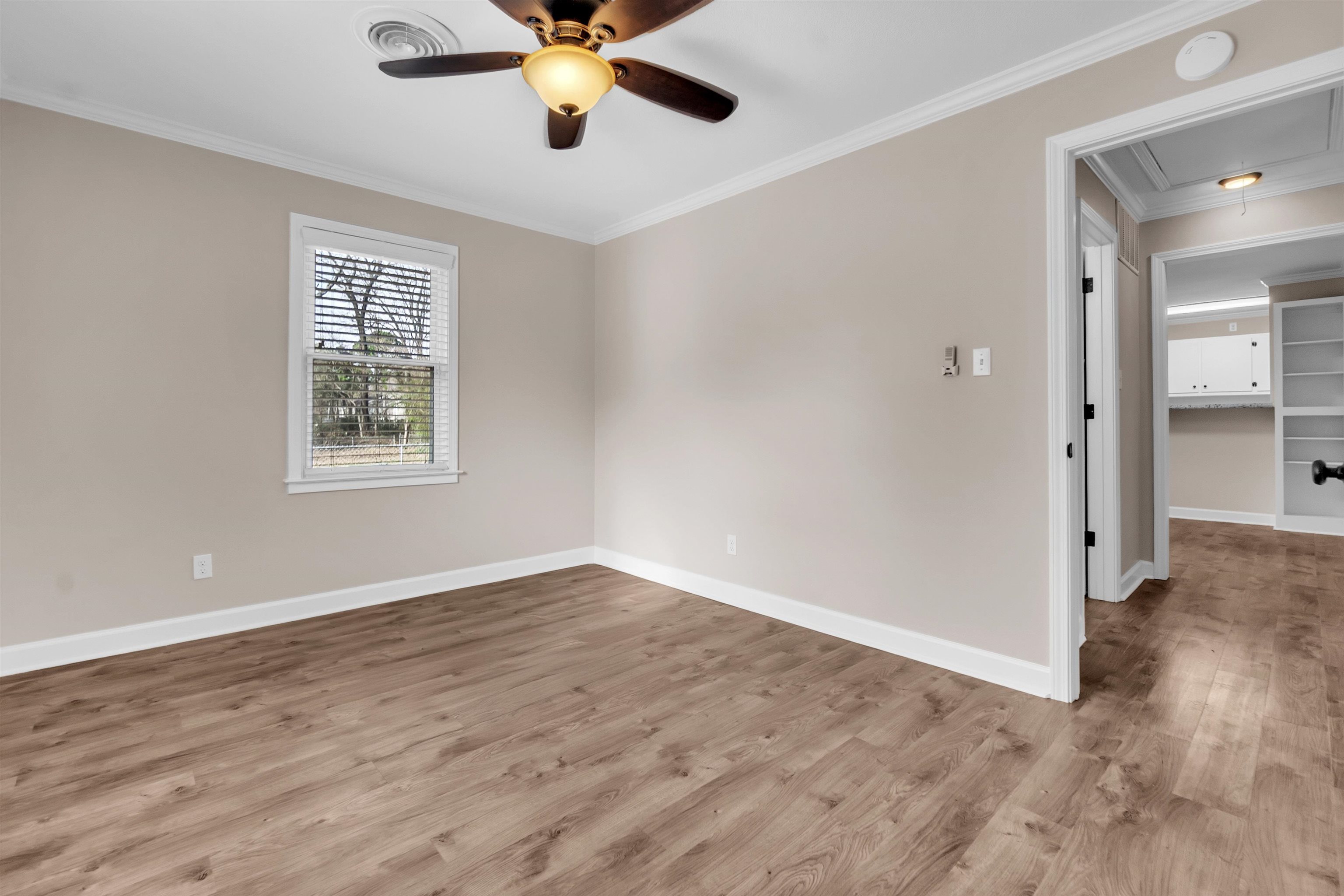 1371 Phillips Road Memphis, TN 38134 - Photo 12 of 35 Unfurnished room featuring attic access, wood finished floors, ceiling fan, and crown molding