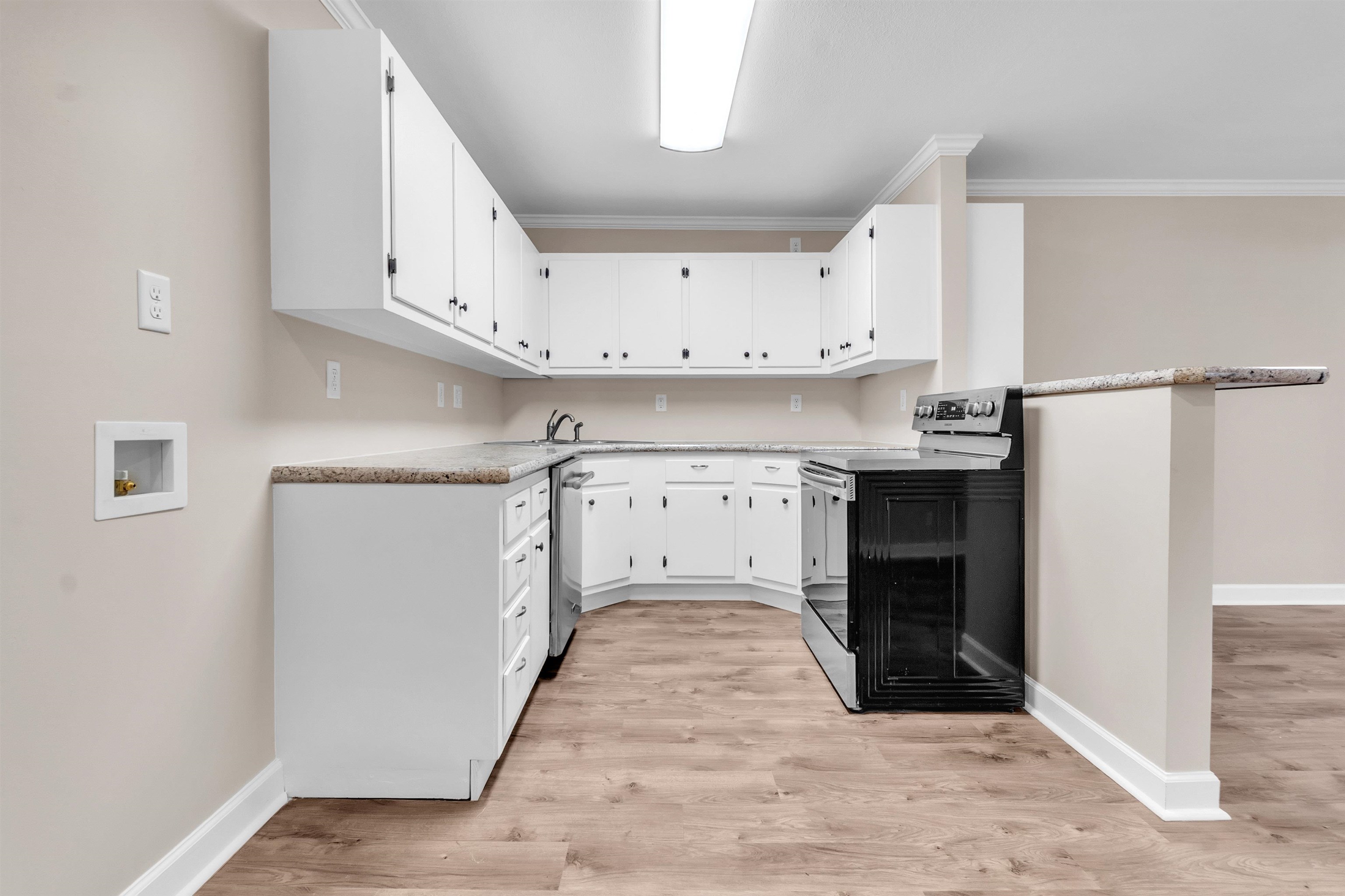 1371 Phillips Road Memphis, TN 38134 - Photo 17 of 35 Kitchen featuring electric range oven, white cabinetry, light countertops, light wood finished floors, and stainless steel dishwasher