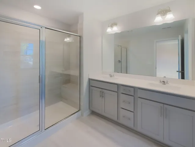 a bathroom with double sink and a mirror
