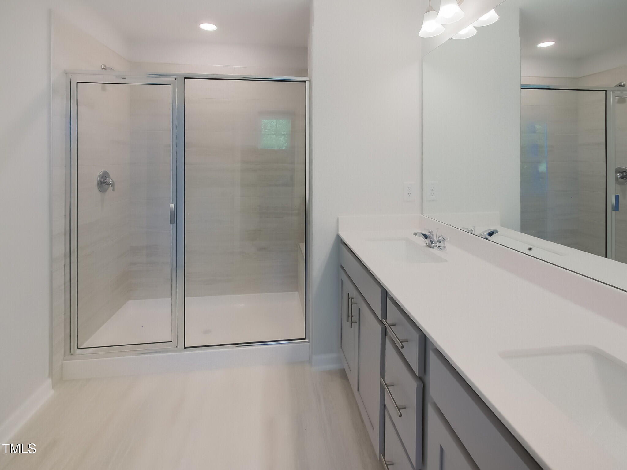 507 Hester Road Durham, NC 27703 - Photo 25 of 33 a bathroom with a double vanity sink a mirror and a shower