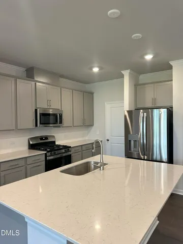 a kitchen with stainless steel appliances granite countertop a sink a stove a refrigerator a microwave and cabinets