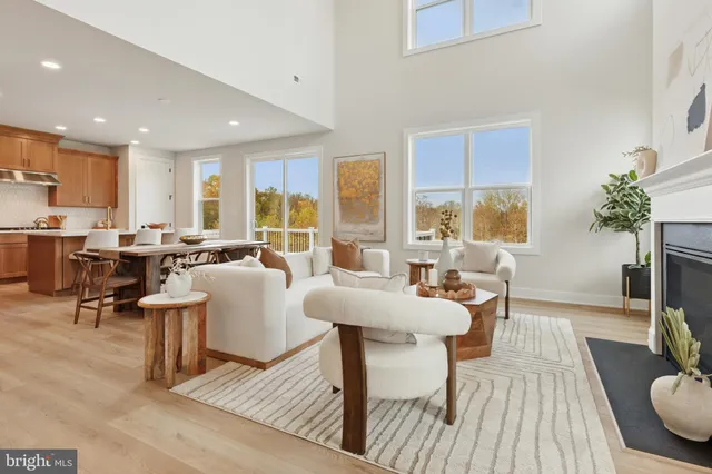 a living room with furniture large window and wooden floor