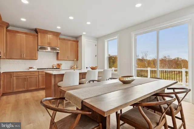 a open dining room with kitchen island a table and chairs in it