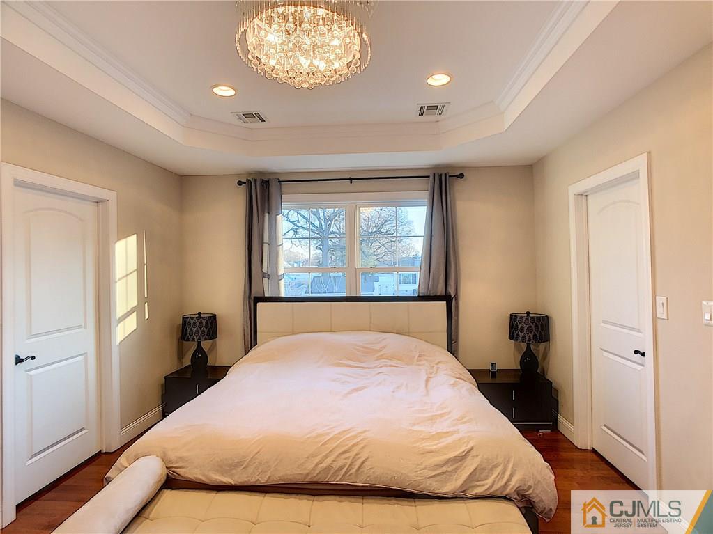 724 Palisade Road Union, NJ 07083 - Photo 12 of 20 a bedroom with a large bed and a chandelier