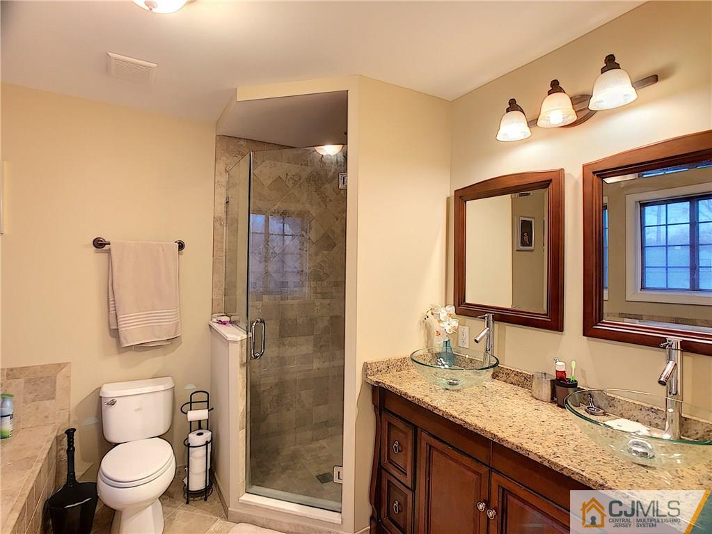 724 Palisade Road Union, NJ 07083 - Photo 14 of 20 a bathroom with a granite countertop sink toilet a mirror a vanity and shower