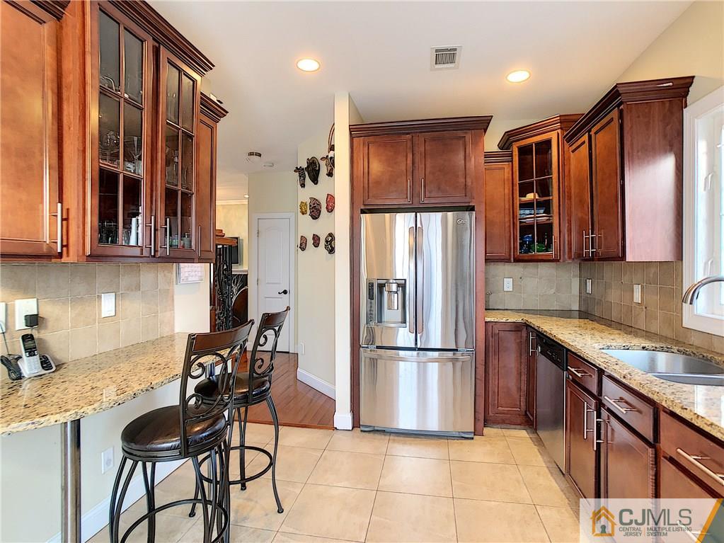 724 Palisade Road Union, NJ 07083 - Photo 4 of 20 a kitchen with granite countertop a refrigerator and a stove top oven