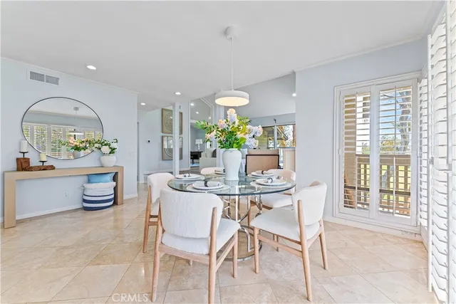 a dining room with furniture a chandelier and kitchen view