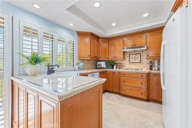 a kitchen with refrigerator cabinets and stove top oven