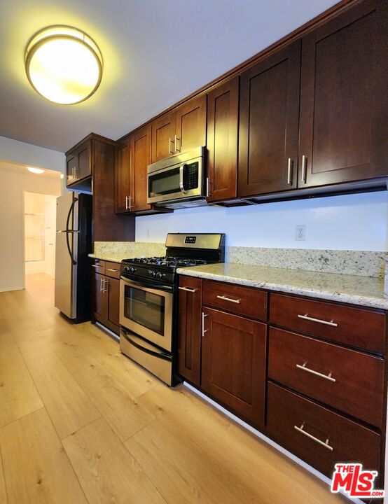 832 3rd Street, Unit 203 Santa Monica, CA 90403 - Photo 11 of 16 a kitchen with stainless steel appliances granite countertop a stove a sink and a refrigerator