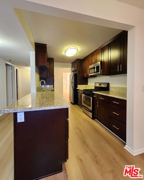 832 3rd Street, Unit 203 Santa Monica, CA 90403 - Photo 12 of 16 a kitchen with a sink and a refrigerator