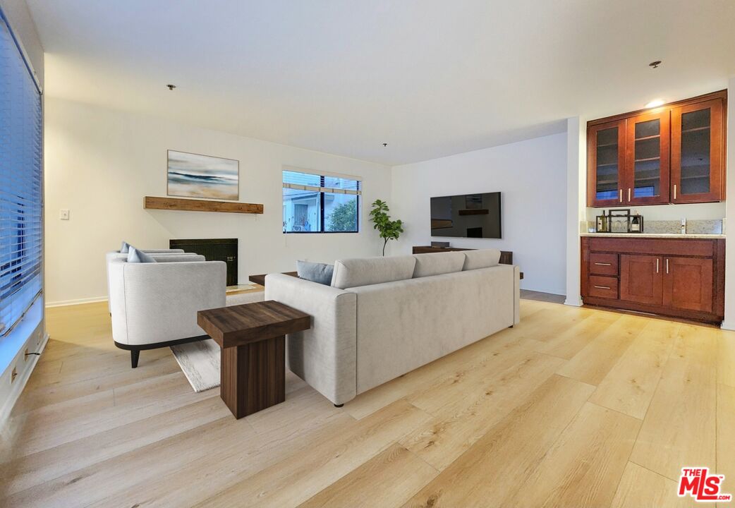832 3rd Street, Unit 203 Santa Monica, CA 90403 - Photo 3 of 16 a living room with furniture and a flat screen tv