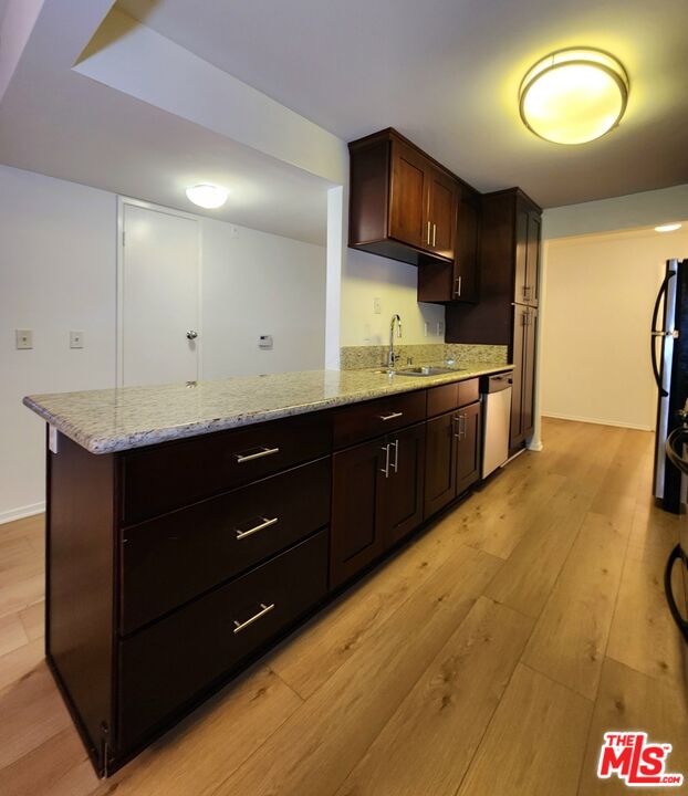832 3rd Street, Unit 203 Santa Monica, CA 90403 - Photo 9 of 16 a kitchen with stainless steel appliances granite countertop a sink a stove a refrigerator cabinets and wooden floor