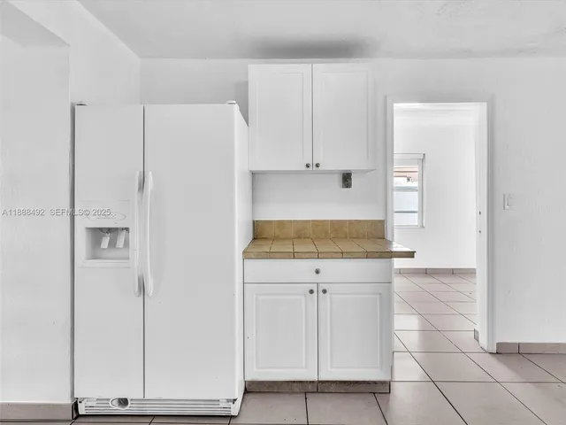 a view of kitchen with granite countertop white cabinets and white appliances