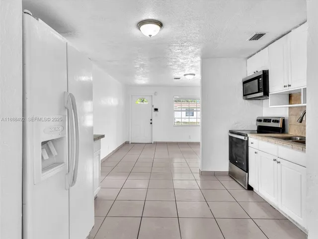 a kitchen with stainless steel appliances a refrigerator and a stove top oven
